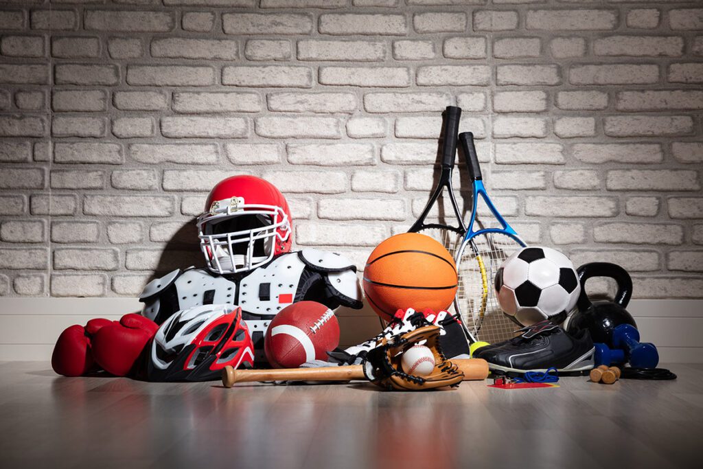 Various types of sports equipment laid out on the floor.