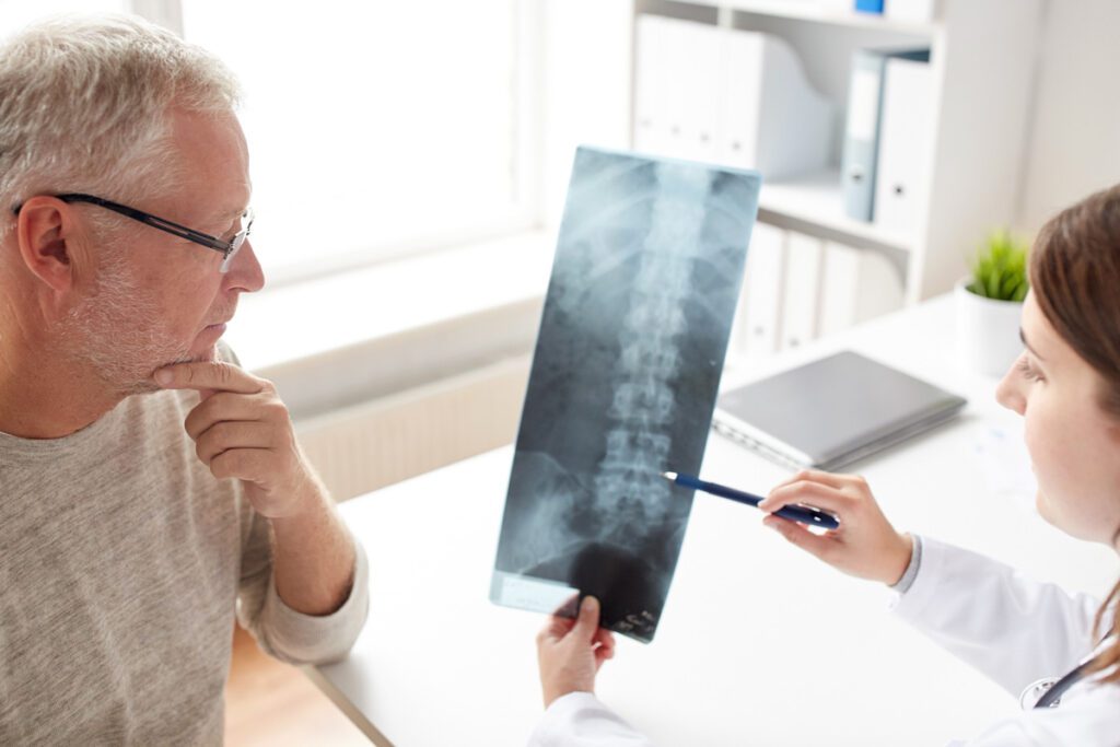 A doctor reviewing a spinal x-ray with their patient.