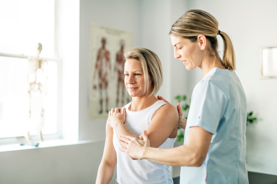 A therapist working with a patient on range of movement for her shoulder.